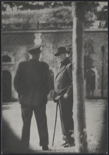 Pétain parlant à un garde dans la cour du fort de Pierre-Levée où il est prisonnier.